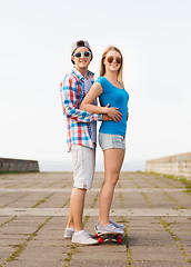 Image showing smiling couple with skateboard outdoors