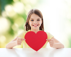 Image showing beautiful little girl sitting at table