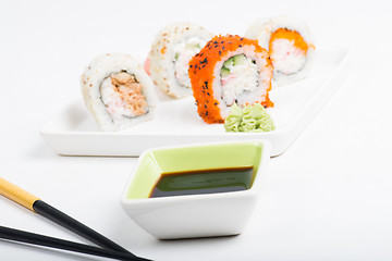 Image showing Focus on soy sauce, shushi rolls in back