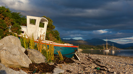 Image showing Small shipwreck at a loch with stone beach