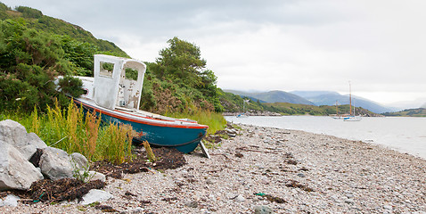 Image showing Small shipwreck at a loch with stone beach