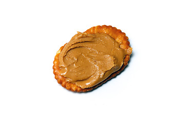 Image showing oval cracker with peanut butter over white