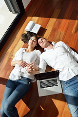 Image showing relaxed young couple working on laptop computer at home