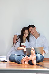 Image showing relaxed young couple working on laptop computer at home