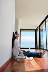 Image showing relaxed young woman at home working on laptop