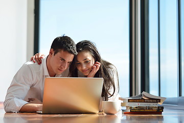 Image showing relaxed young couple working on laptop computer at home