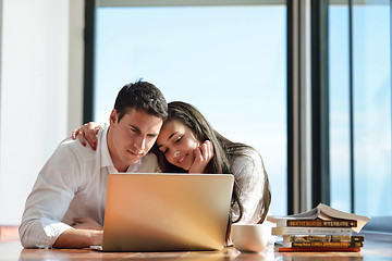 Image showing relaxed young couple working on laptop computer at home