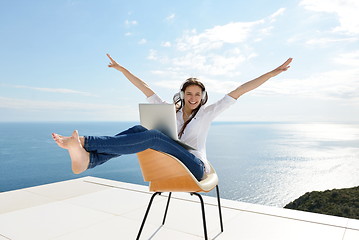 Image showing relaxed young woman at home working on laptop