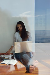 Image showing relaxed young woman at home working on laptop computer