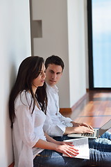 Image showing relaxed young couple working on laptop computer at home