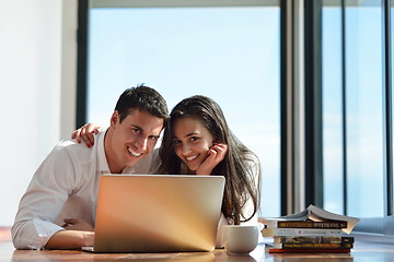 Image showing relaxed young couple working on laptop computer at home