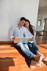 Image showing relaxed young couple working on laptop computer at home