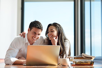 Image showing relaxed young couple working on laptop computer at home