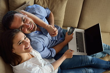 Image showing relaxed young couple working on laptop computer at home