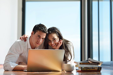 Image showing relaxed young couple working on laptop computer at home