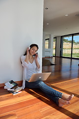 Image showing relaxed young woman at home working on laptop