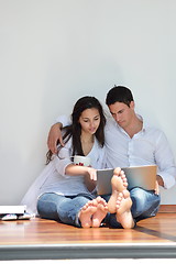 Image showing relaxed young couple working on laptop computer at home