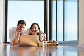 Image showing relaxed young couple working on laptop computer at home