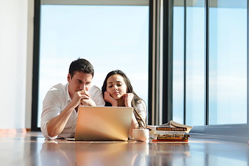 Image showing relaxed young couple working on laptop computer at home