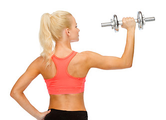 Image showing sporty woman with heavy steel dumbbell from back