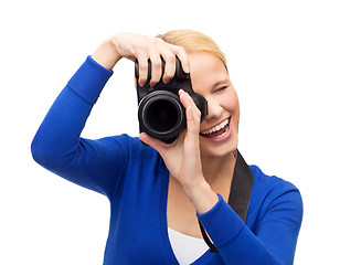 Image showing smiling woman taking picture with digital camera