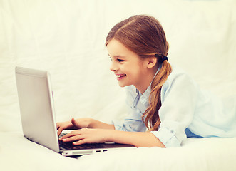 Image showing smiling girl with laptop computer at home