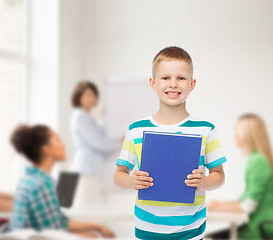 Image showing smiling little student boy with blue book