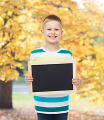 Image showing smiling little boy holding blank black chalkboard