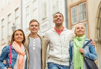 Image showing group of smiling friends walking in the city