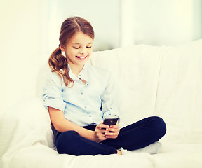 Image showing smiling girl with smartphone at home