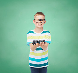 Image showing smiling boy in eyeglasses holding spectacles