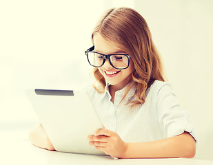 Image showing smiling girl in glasses with tablet pc at school