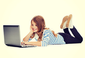 Image showing smiling student girl with laptop computer lying