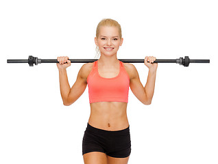 Image showing smiling sporty woman exercising with barbell