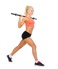 Image showing smiling sporty woman exercising with barbell