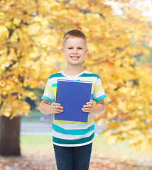 Image showing smiling little student boy with blue book