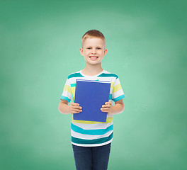 Image showing smiling little student boy with blue book