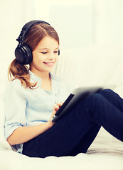 Image showing girl with tablet pc and headphones at home