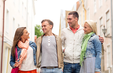 Image showing group of smiling friends walking in the city