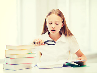 Image showing girl reading book with magnifier at school