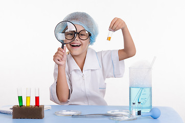 Image showing Chemist with the powder and a magnifying glass