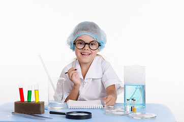 Image showing Chemist making notes in notepad