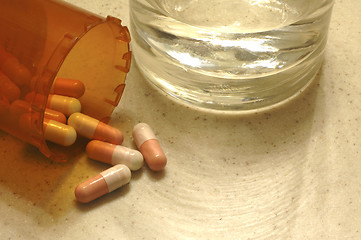 Image showing Drug capsules with a glass of water