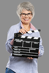 Image showing Elderly woman holding a clapboard