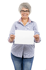 Image showing Elderly woman holding a blank paper card