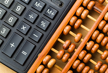 Image showing Ancient abacus and modern calculator 