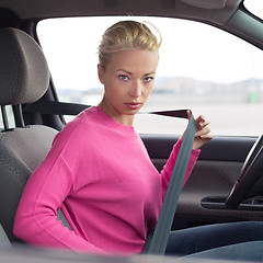 Image showing Beautiful woman fastening seat belt.