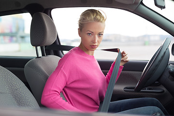 Image showing Beautiful woman fastening seat belt.