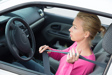 Image showing Beautiful woman fastening seat belt.