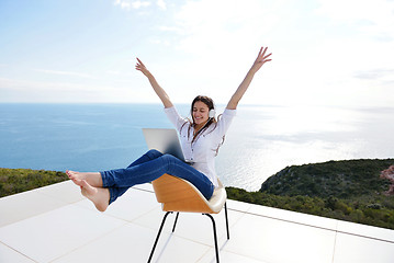 Image showing relaxed young woman at home working on laptop